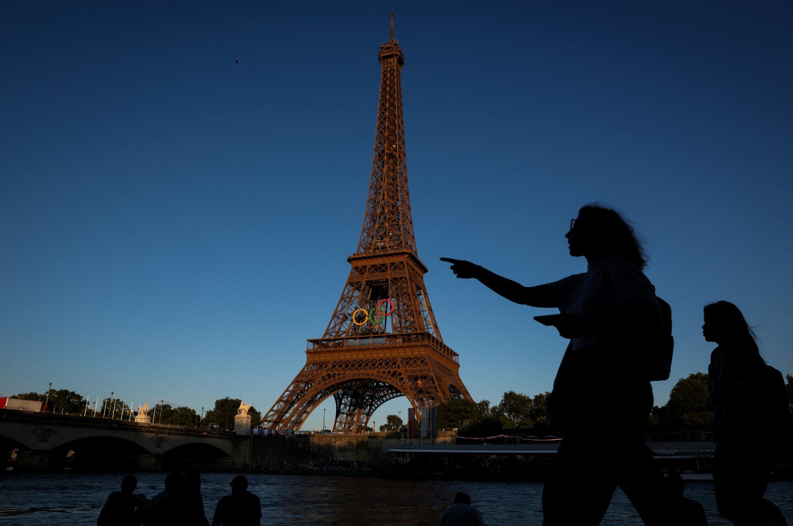 People walk past the Eiffel Tower during the Olympic Games in Paris, France, July 28, 2024. (Reuters Photo)