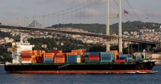 A container ship sails through the Bosporus as Estonian athlete Jaan Roose walks on slackline across the July 15 Martyrs' Bridge, in Istanbul, Türkiye, Sept. 15, 2024. (Reuters Photo)