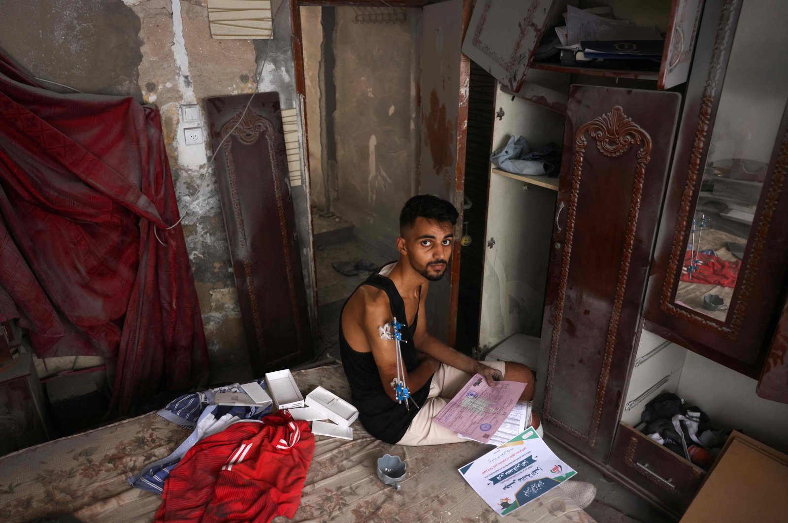 Injured Palestinian student Fares al-Farra, 19, and a friend salvage some of his academic documents from the rubble of his home, destroyed due to Israeli bombardment, Khan Yunis, in the southern Gaza Strip, Palestine, Sept. 16, 2024. (AFP Photo)