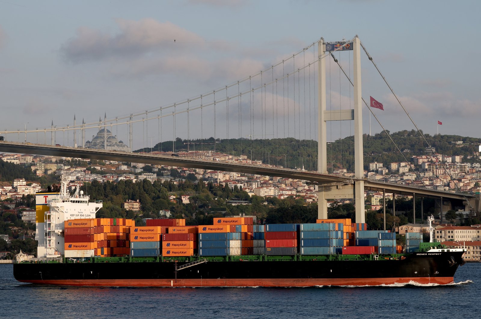 A container ship sails through the Bosporus as Estonian athlete Jaan Roose walks on slackline across the July 15 Martyrs&#039; Bridge, in Istanbul, Türkiye, Sept. 15, 2024. (Reuters Photo)