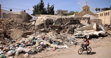 A Palestinian boy rides a bicycle before the destroyed 12th century Greek Orthodox Church of St. Porphyrios (Porphyrius) in Gaza City, Gaza, Palestine, Sept. 22, 2024. (AFP Photo)