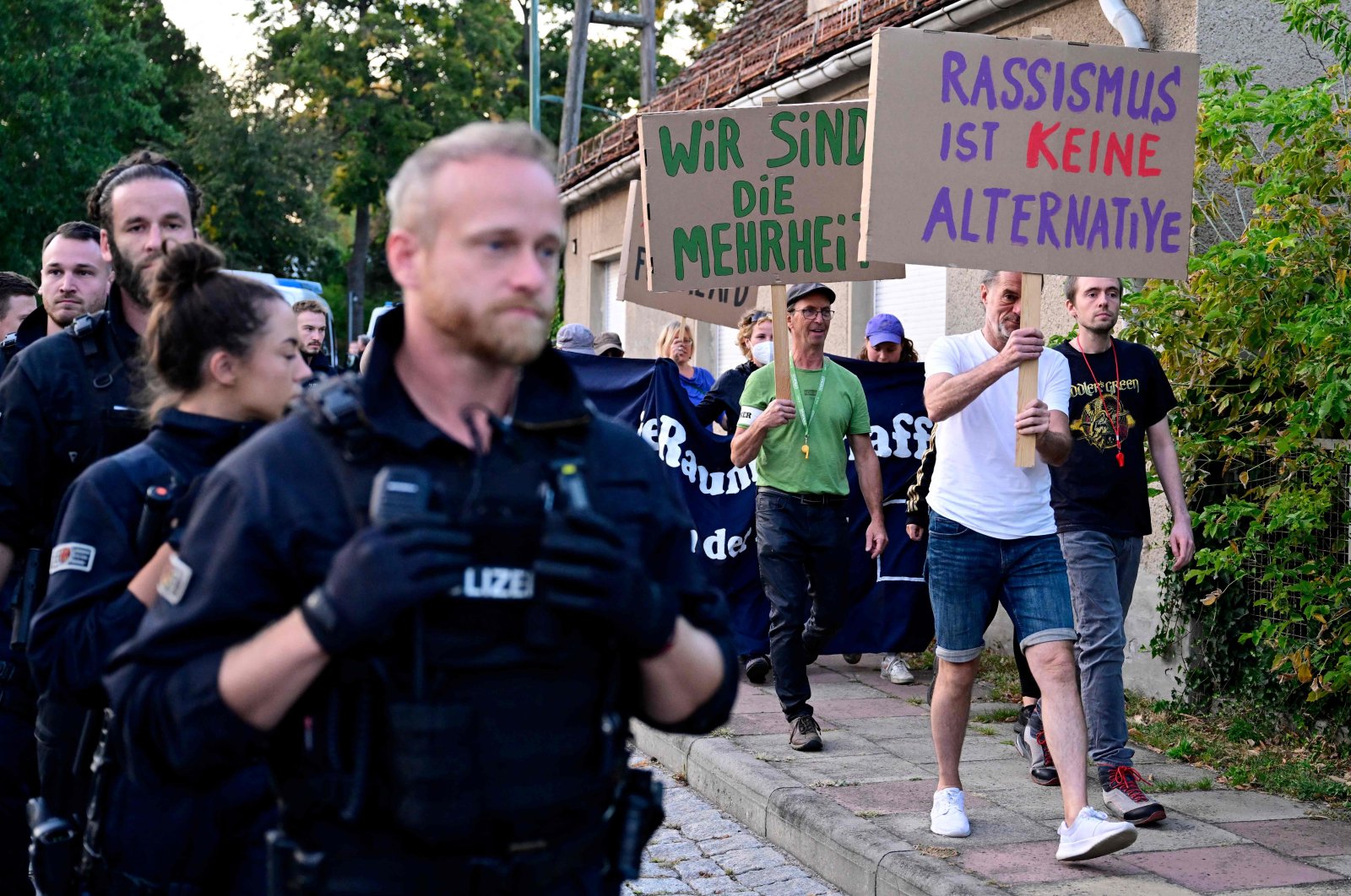 Police officers accompany demonstrators with placards reading "Racism is no alternative" close to the election party venue of the far-right Alternative for Germany (AfD) party, Potsdam, Germany, Sept. 22, 2024. (AFP Photo)