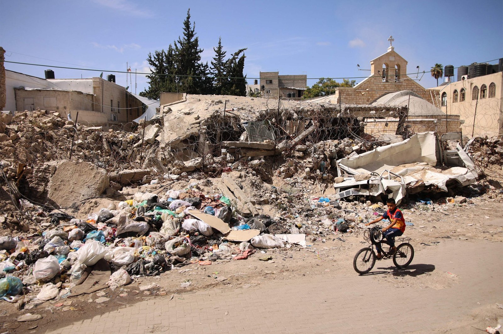 A Palestinian boy rides a bicycle before the destroyed 12th century Greek Orthodox Church of St. Porphyrios (Porphyrius) in Gaza City, Gaza, Palestine, Sept. 22, 2024. (AFP Photo)