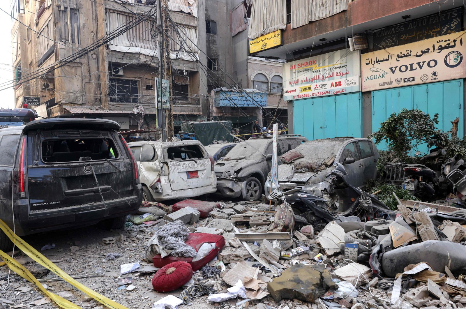 Debris lie around destroyed vehicles in a street under a residential building whose top two floors were hit by an Israeli strike in the Ghobeiri area of Beirut&#039;s southern suburbs, Sept. 24, 2024. (AFP Photo)