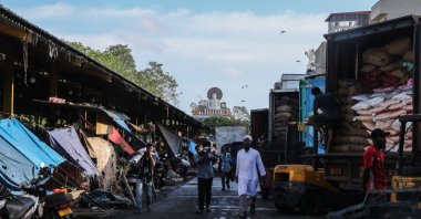 People walk past trucks loaded with goods in a street at the commercial hub of Colombo, Sri Lanka, Sept. 24, 2024. (EPA Photo)