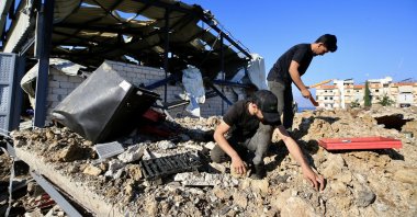 People inspect the area near a damaged building after Israeli raids in Jiyeh, South Lebanon, Sept. 25, 2024. (EPA Photo)