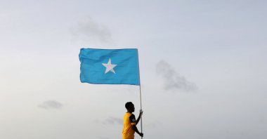 Somali youth holds the national flag at Lido Beach, Mogadishu's Abdiaziz District, Somalia, June 18, 2021. (Reuters Photo)