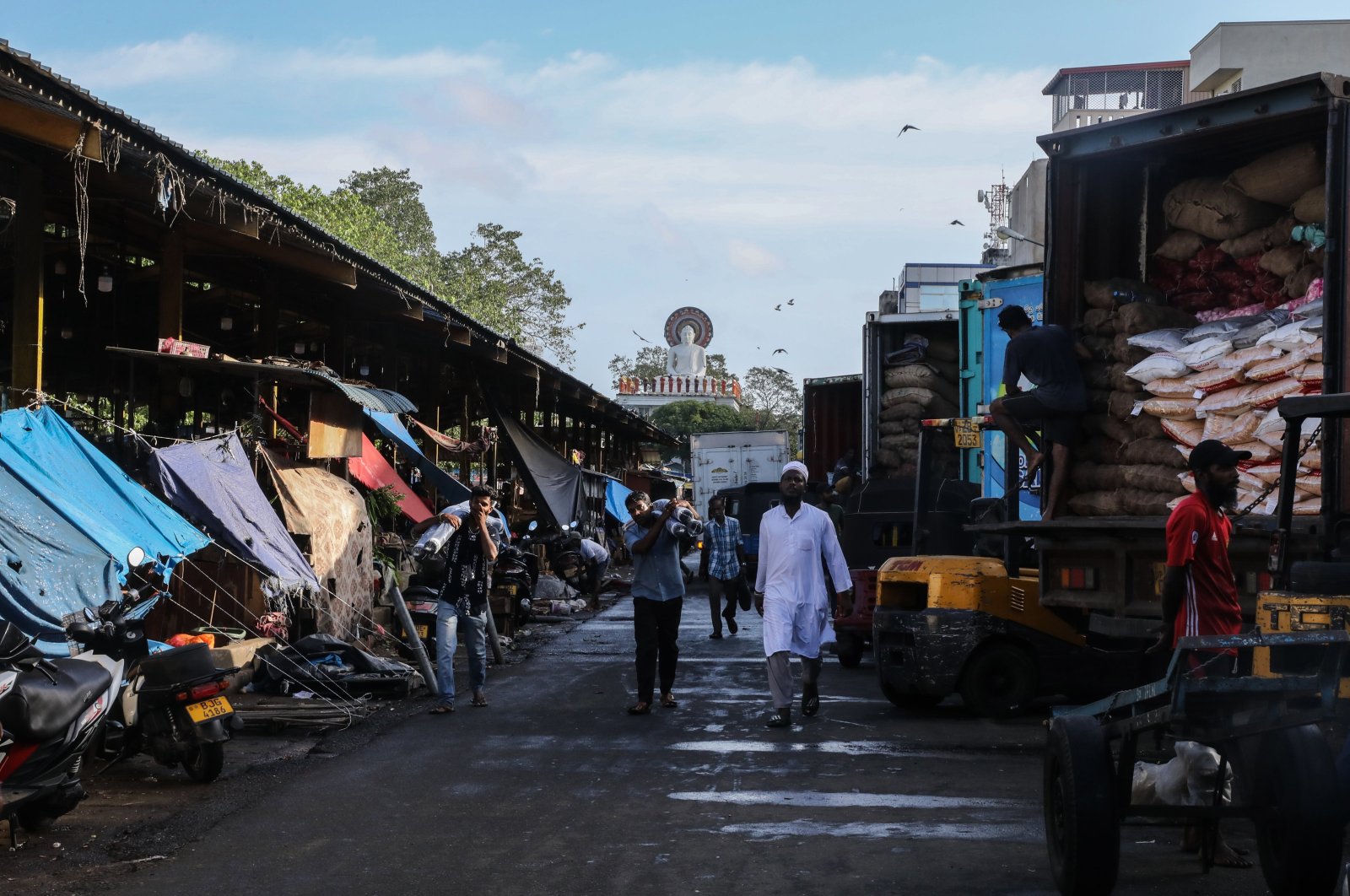 People walk past trucks loaded with goods in a street at the commercial hub of Colombo, Sri Lanka, Sept. 24, 2024. (EPA Photo)