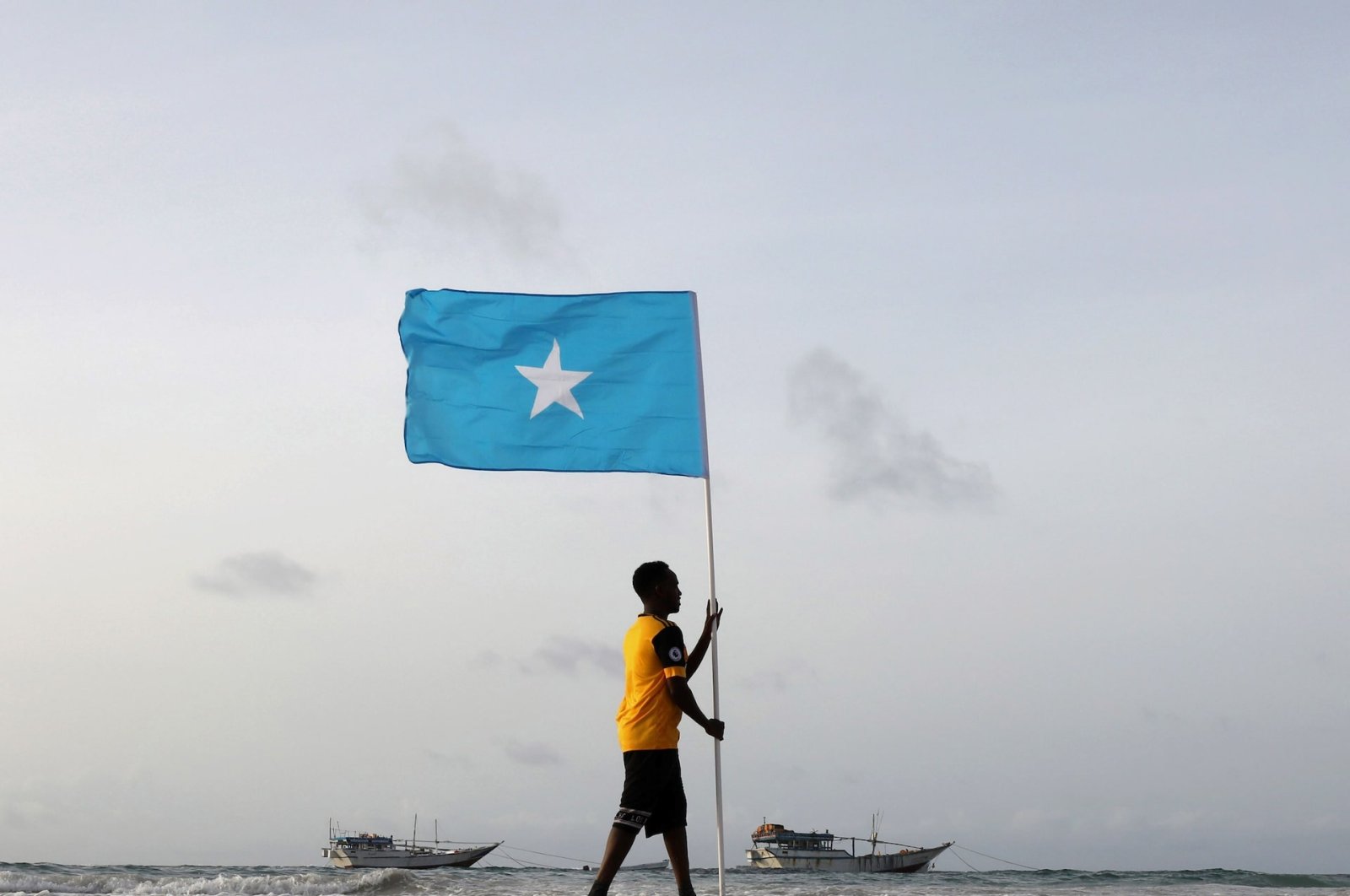 Somali youth holds the national flag at Lido Beach, Mogadishu&#039;s Abdiaziz District, Somalia, June 18, 2021. (Reuters Photo)