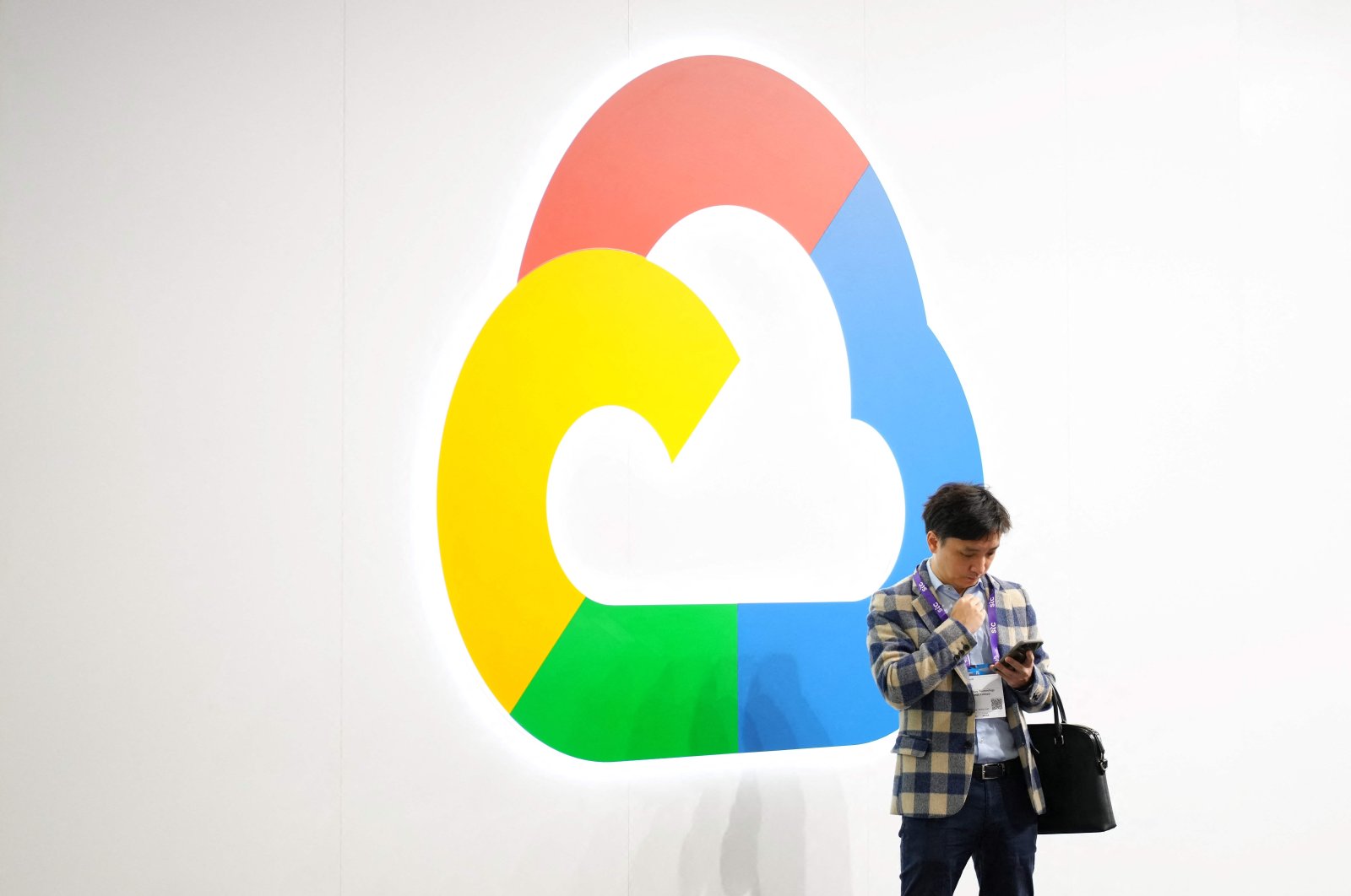 A man uses his phone next to Google Cloud&#039;s logo at the Mobile World Congress (MWC), the telecom industry&#039;s biggest annual gathering, Barcelona, Spain, Feb. 27, 2024. (AFP Photo)