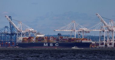 A small boat passes by a cargo ship near the Seagirt Marine Terminal as the main shipping channel at the Port of Baltimore prepares to fully reopen in Baltimore, Maryland, U.S., June 10, 2024. (Reuters Photo)