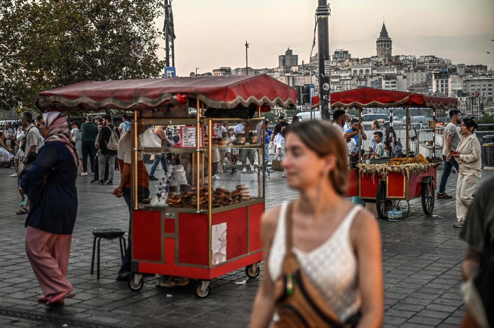 A street vendor sells corn and traditional Turkish bakery &quot;simit&quot; as people pass by in the famous Eminönü neighborhood in Istanbul, Türkiye, Aug. 30, 2024.