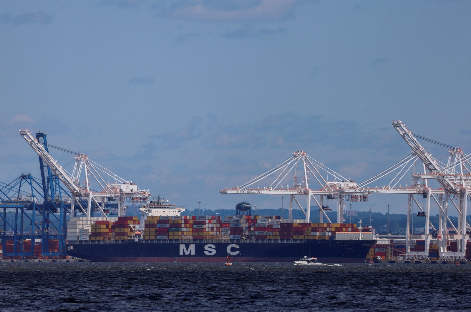 A small boat passes by a cargo ship near the Seagirt Marine Terminal as the main shipping channel at the Port of Baltimore prepares to fully reopen in Baltimore, Maryland, U.S., June 10, 2024. (Reuters Photo)