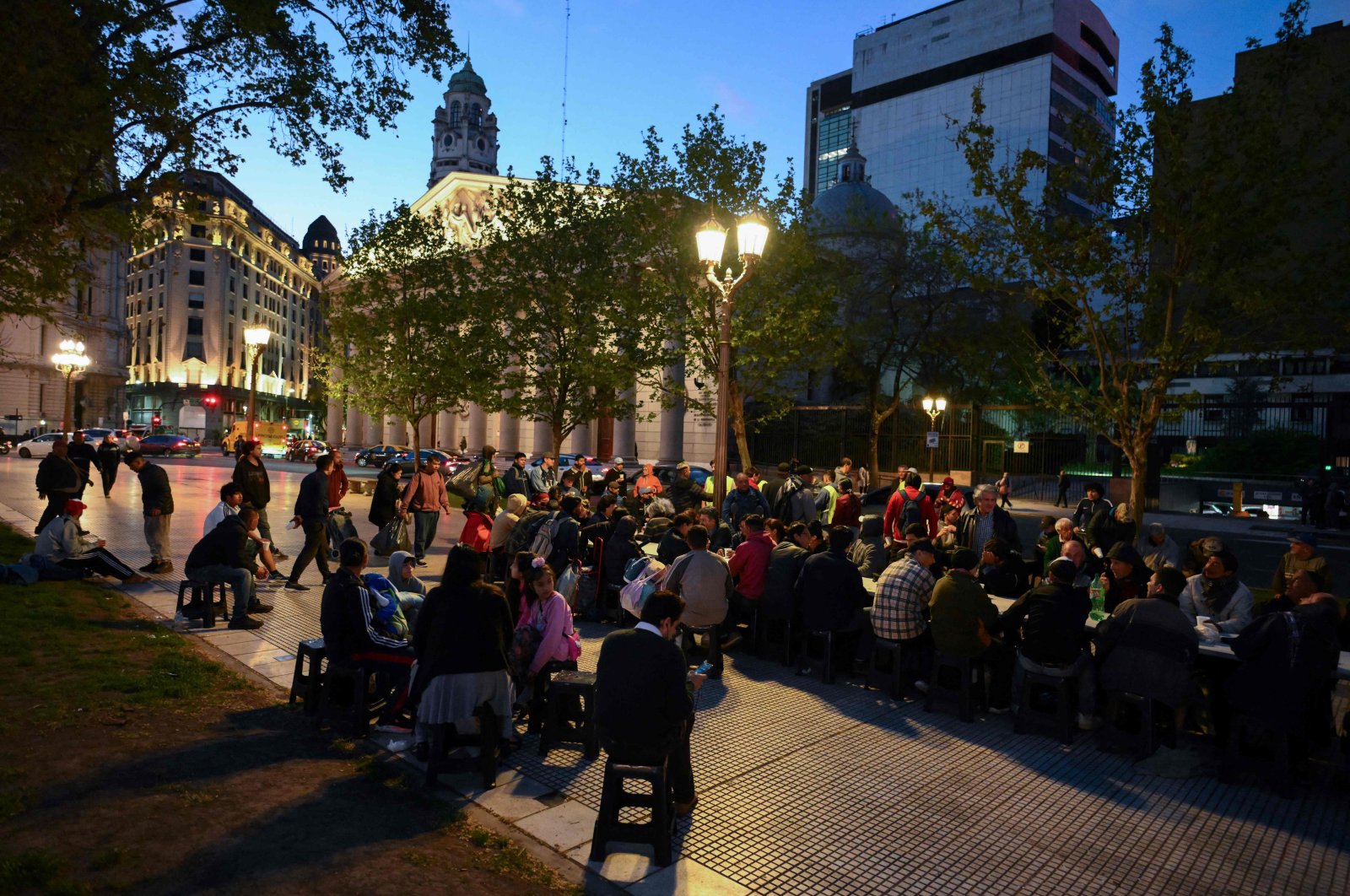 People eat food provided by the Red Solidaria organization at Plaza de Mayo square in front of Casa Rosada presidential palace in Buenos Aires, Argentina, Sept. 25, 2024. (AFP Photo)