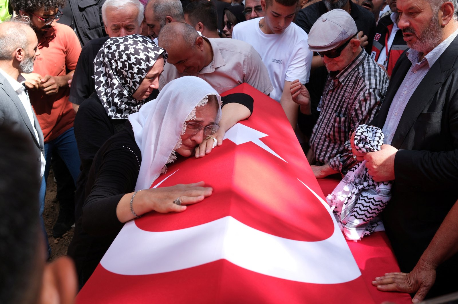 A relative of Ayşenur Ezgi Eygi, a Turkish-American activist killed in the Israeli-occupied West Bank, mourns over her Turkish flag-draped coffin during the funeral ceremony at a cemetery in Didim, Aydın, Türkiye, Sept. 14, 2024. (Reuters Photo)