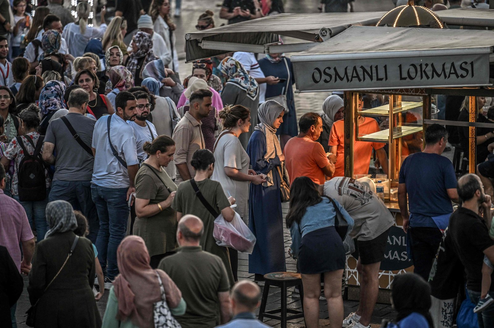 Street vendors sell traditional Turkish sweet &quot;lokma&quot; as people queue up in the famous Eminönü neighborhood of Istanbul, Türkiye, Aug. 30, 2024. (AFP Photo)