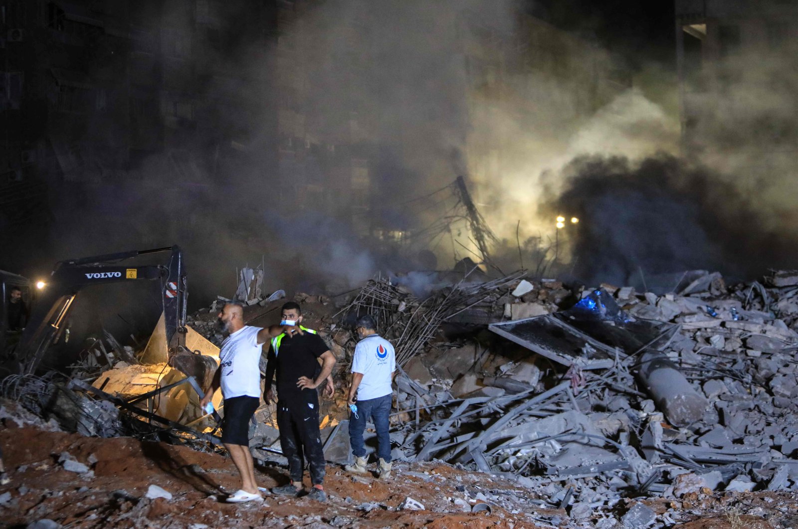 Rescuers stand on the rubble of a building destroyed in an Israeli air strike in the Haret Hreik neighborhood of Beirut&#039;s southern suburbs on Sept. 27, 2024. (AFP Photo)