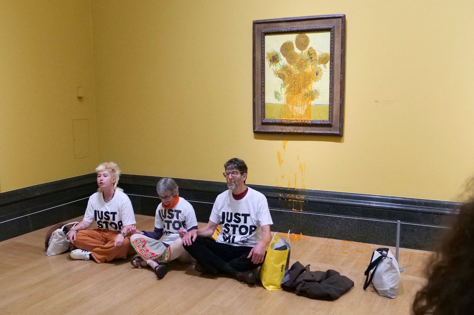 A handout picture from the Just Stop Oil climate campaign group shows three activists sitting on the floor under Vincent Van Gogh&#039;s "Sunflowers" in central London, U.K., Sept. 27, 2024. (AFP Photo)