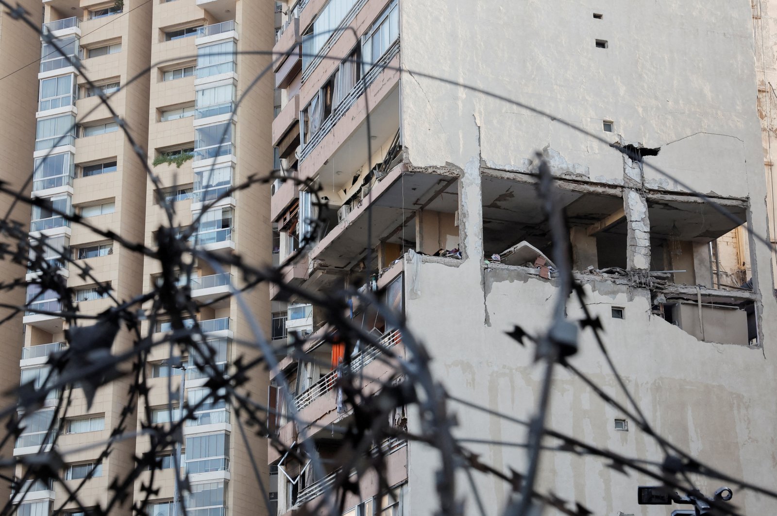 A building damaged in an Israeli strike is seen through a razor wire fence, in Kola, central Beirut, Lebanon, Sept. 30, 2024. (Reuters Photo)