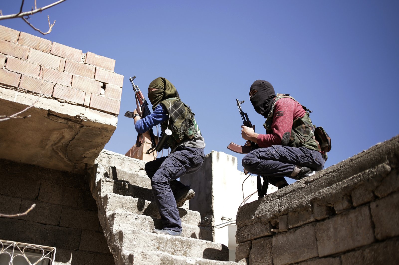 Two PKK terrorists run as they attack Turkish security forces in the Nusaydin district, bordering Syria, in southeastern Mardin province, Türkiye, March 1, 2016. (AP Photo)