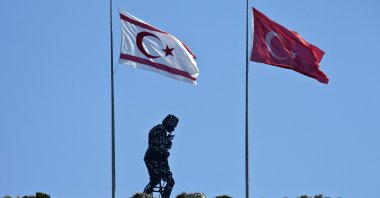 A hillside monument dedicated to Mustafa Kemal Atatürk, the founder of modern Türkiye (1881-1938), between flags of the Turkish Republic of Northern Cyprus (TRNC) and Türkiye, Girne (Kyrenia), TRNC, Oct. 1, 2010. (Getty Images Photo)
