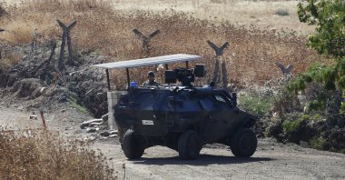 A Turkish soldier stands next to an armored personnel carrier securing a road after bombing Daesh targets across the border with Syria, near Kilis, southeastern Türkiye, July 24, 2015. (AP Photo)