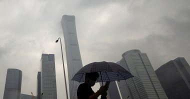 A man walks in the Central Business District on a rainy day, Beijing, China, July 12, 2023. (Reuters Photo)