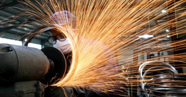 A worker wearing a face mask works on a production line manufacturing bicycle steel rims at a factory in Hangzhou, Zhejiang province, China, March 2, 2020. (Reuters Photo)