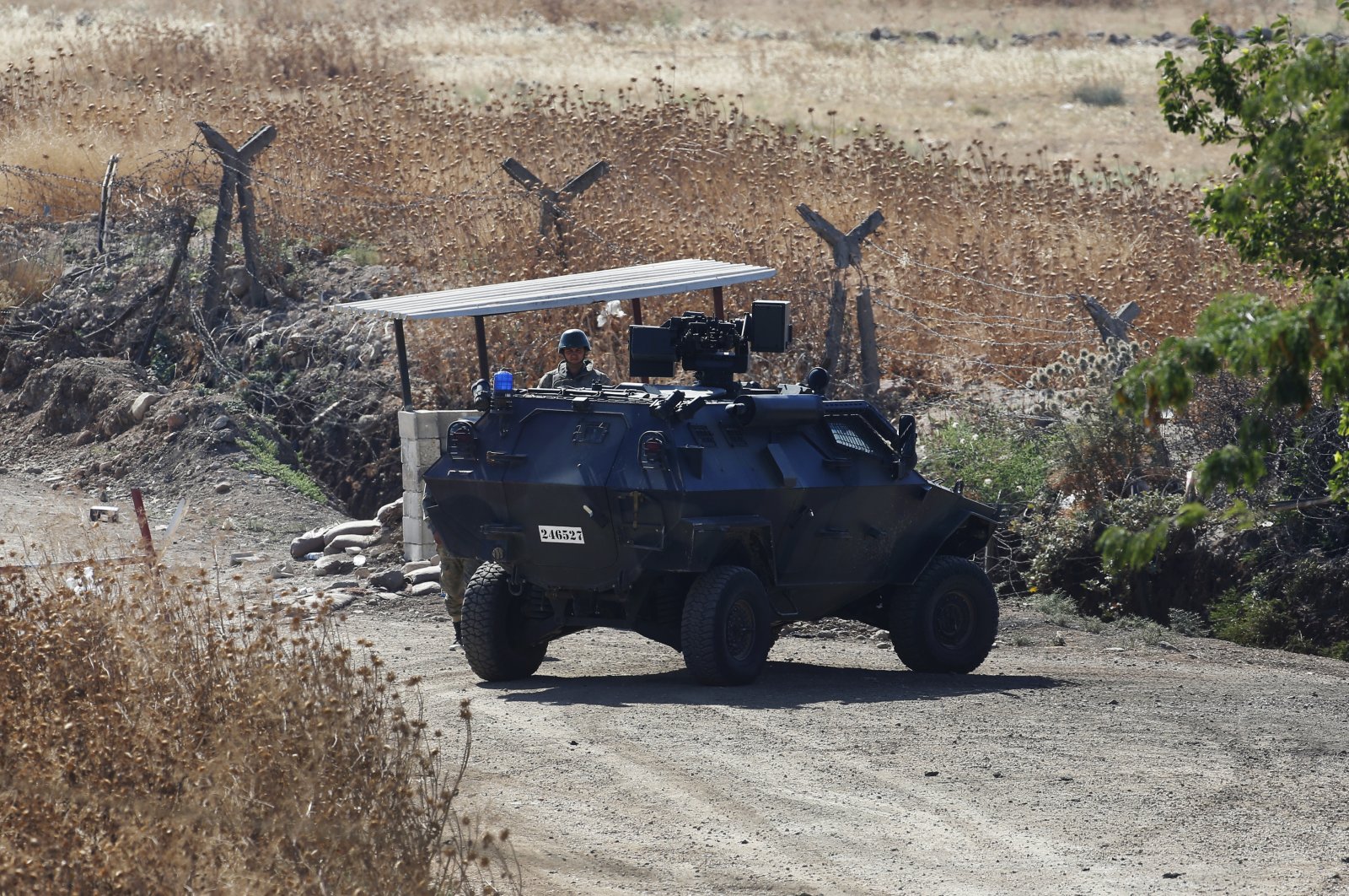 A Turkish soldier stands next to an armored personnel carrier securing a road after bombing Daesh targets across the border with Syria, near Kilis, southeastern Türkiye, July 24, 2015. (AP Photo)