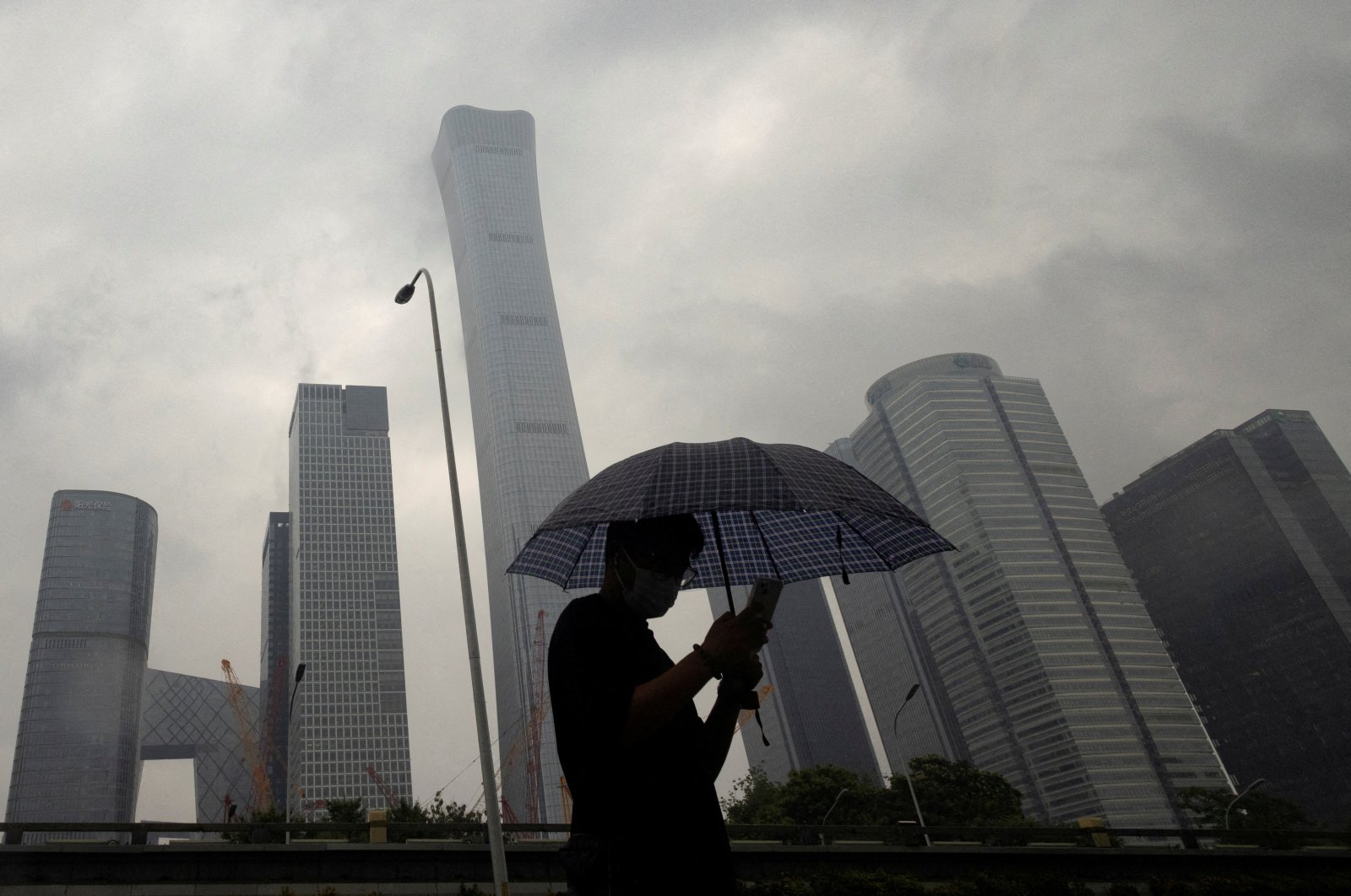 A man walks in the Central Business District on a rainy day, Beijing, China, July 12, 2023. (Reuters Photo)