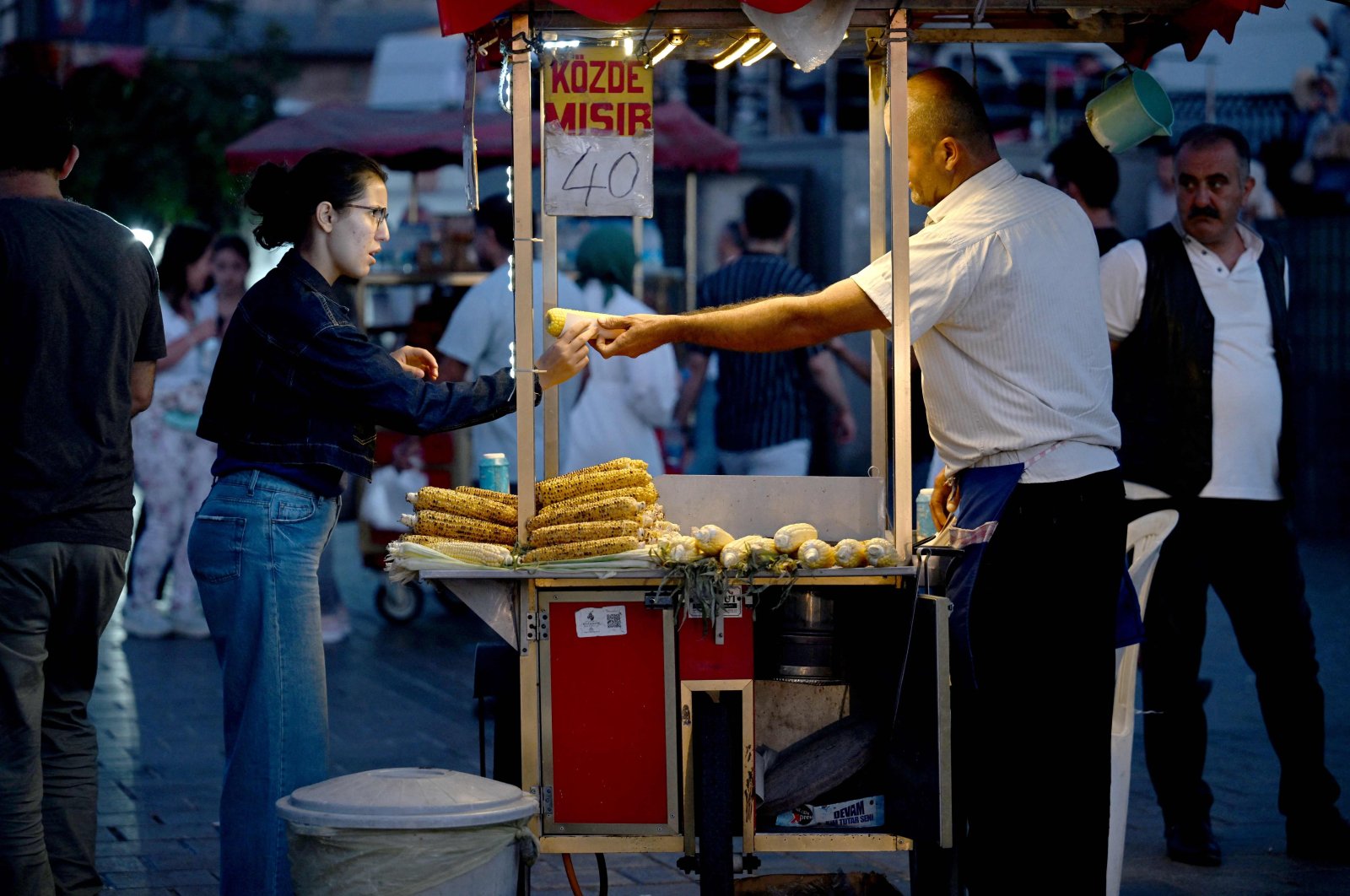 A street vendor sells corn as he waits for customers in the famous Eminönü neighborhood of Istanbul, Türkiye, Aug. 30, 2024. (AFP Photo)