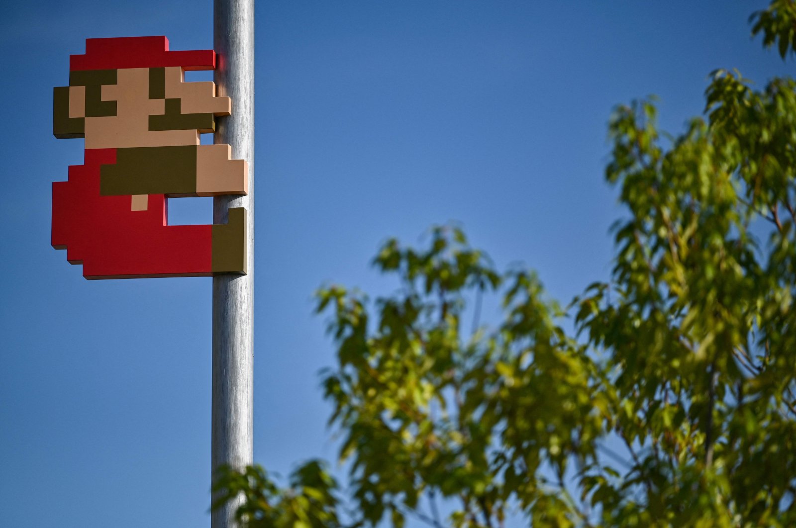 This photo shows a Super Mario on a pole in the courtyard during a media preview of the new Nintendo Museum in the suburbs of Kyoto, Japan, Sept. 24, 2024. (AFP Photo)