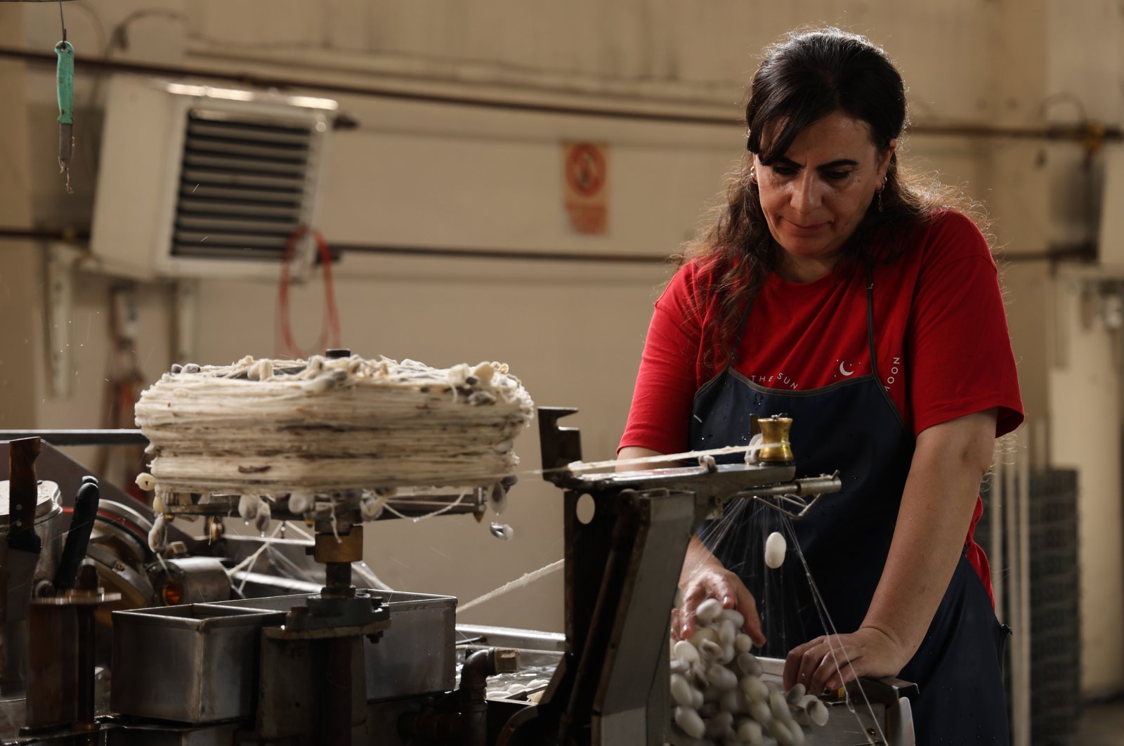 One of the employees working on the thread-producing machine, Diyarbakır, Türkiye, Oct. 2, 2024. (IHA Photo)