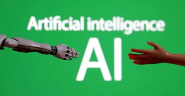 Words reading "Artificial intelligence AI," and miniatures of robot and toy hands are pictured in this illustration taken on Dec. 14, 2023. (Reuters Photo)