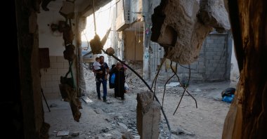 Palestinians walk past damaged buildings, following an Israeli military raid, in Tulkarm, in the Israeli-occupied West Bank, Sept.12, 2024. (Reuters Photo)