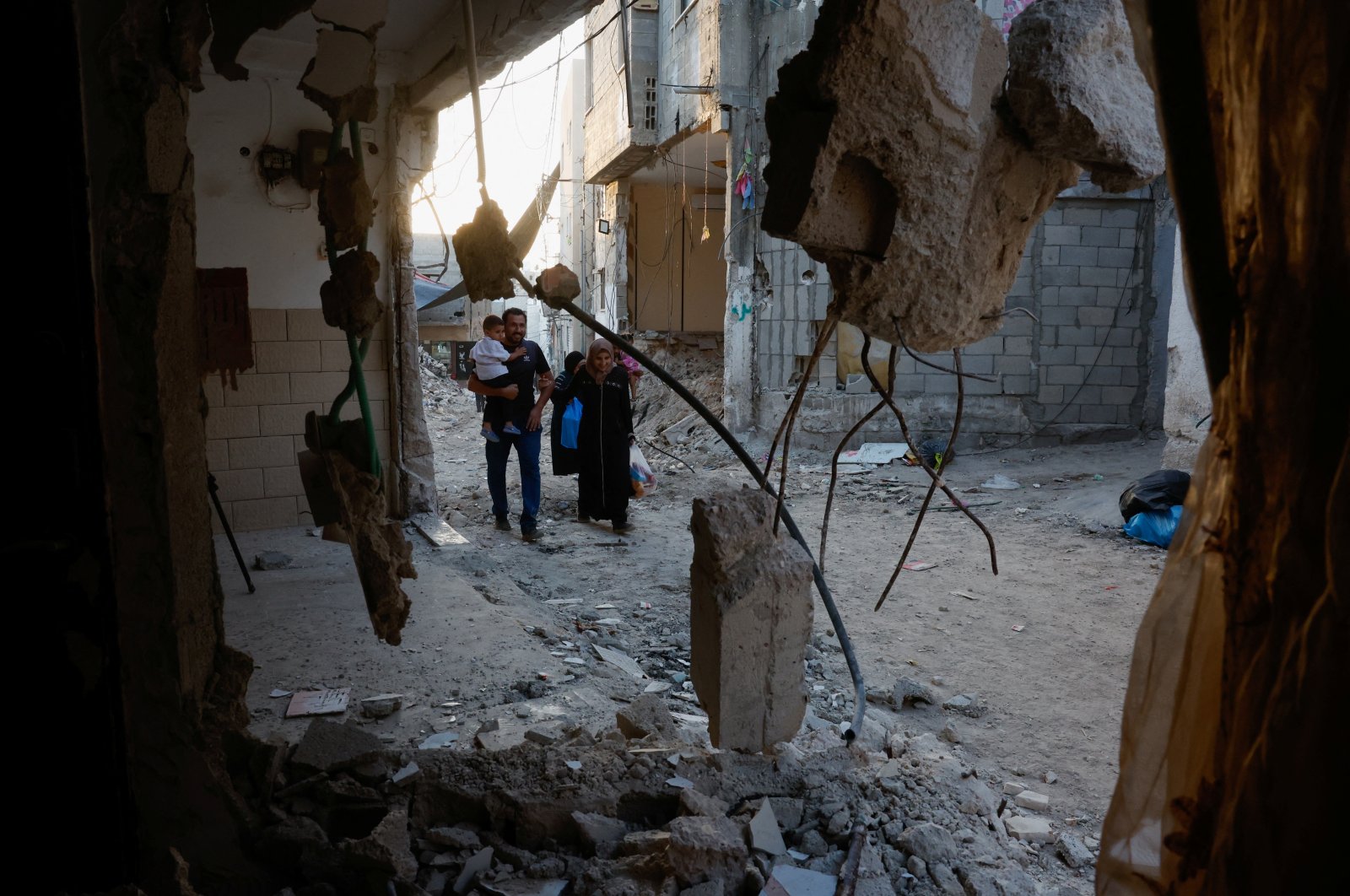 Palestinians walk past damaged buildings, following an Israeli military raid, in Tulkarm, in the Israeli-occupied West Bank, Sept.12, 2024. (Reuters Photo)