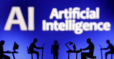 This illustration shows figurines with computers and smartphones in front of the words &quot;AI Artificial Intelligence,&quot; Feb. 19, 2024. (Reuters Photo)