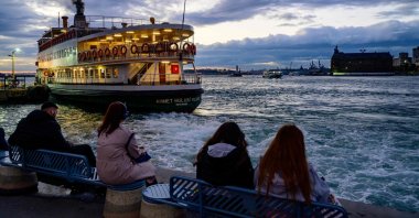 People watch as a ferry departs from the Kadiköy pier at sunset, Istanbul, Türkiye, Sept. 30, 2024. (AFP Photo)