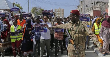 A Somali soldier controls the crowd as thousands of people protest an agreement signed between Ethiopia and the breakaway region of Somaliland in Mogadishu, Somalia, Jan.3, 2024. (AP Photo)