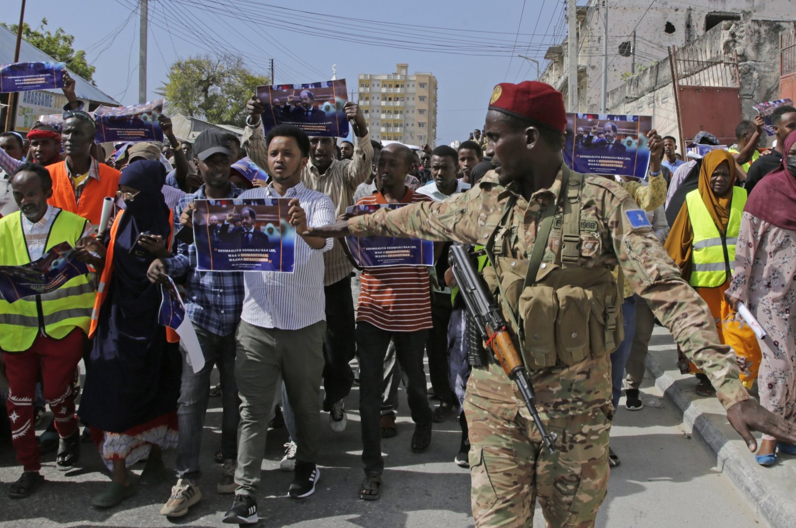 A Somali soldier controls the crowd as thousands of people protest an agreement signed between Ethiopia and the breakaway region of Somaliland in Mogadishu, Somalia, Jan.3, 2024. (AP Photo)