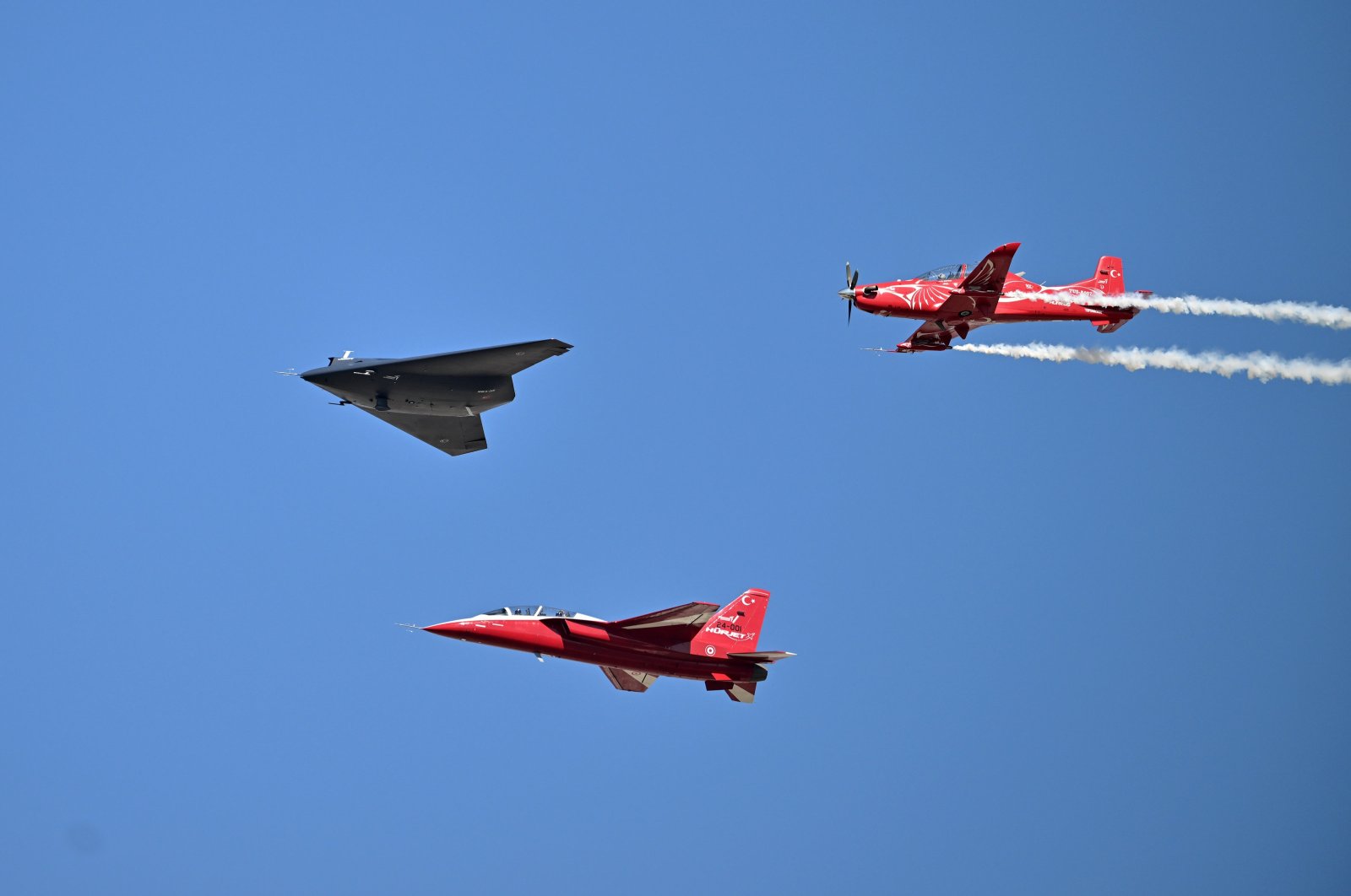 Türkiye&#039;s new jet-powered stealth combat drone Anka-3 (C) is accompanied by the indigenous advanced jet trainer Hürjet and basic trainer aircraft Hürküş, on its first public flight during Teknofest, Adana, Türkiye, Oct. 3, 2024. (AA Photo)