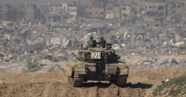 Israeli soldiers stand on a tank as they approach the Gaza Strip, as seen from a position on the Israeli side of the border, Jan.19, 2024.  (Getty Images Photo)