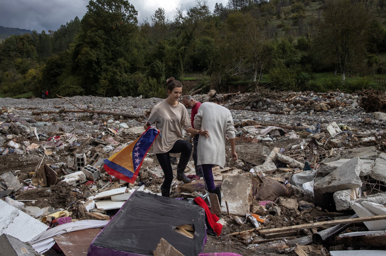 A girl carries a Bosnian flag as she stands next to her destroyed house after floods and landslides in a village of Trusina, Bosnia and Herzegovina, Oct. 6, 2024. (Reuters Photo)