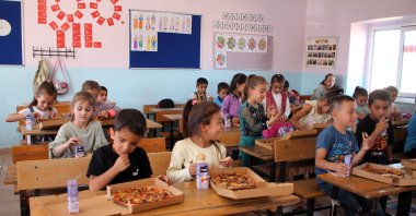 Students enjoy their pizza together in class, Mardin, Türkiye, Oct. 7, 2024. (IHA Photo)
