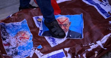A protester steps on a picture of Israel's Prime Minister Benjamin Netanyahu during a rally on the eve of the anniversary of the Oct. 7 Hamas attack, at the Beyazıt Square, Istanbul, Türkiye, Oct.  6, 2024. (AFP Photo)