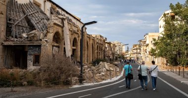 Journalists walk during an organized tour past partially collapsed abandoned buildings in Varosha, in the fenced-off area of Famagusta, TRNC, June 19, 2023. (AFP Photo)