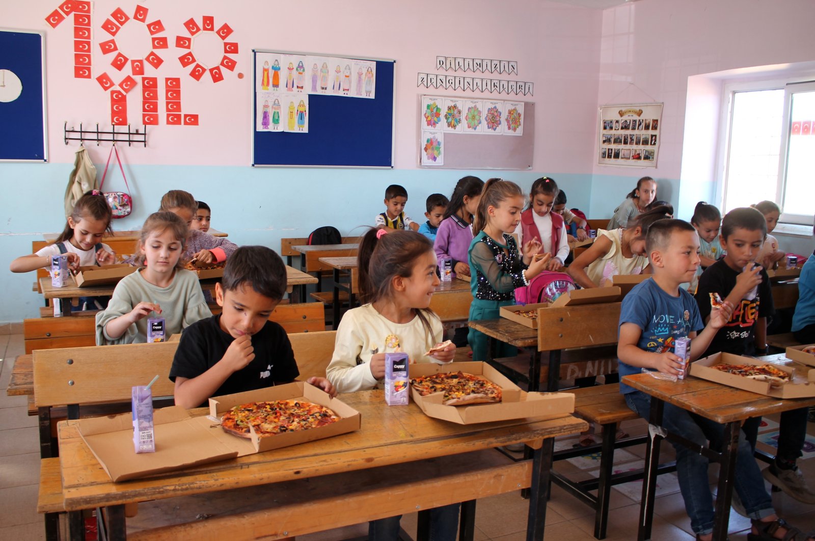 Students enjoy their pizza together in class, Mardin, Türkiye, Oct. 7, 2024. (IHA Photo)