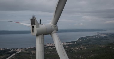 Employees from Akfen Renewable Energy Group’s, Çanakkale Wind Power Plant, do a routine maintenance check of equipment on the top of a wind turbine in Canakkale, Türkiye, Dec. 17, 2021. (Getty Images Photo)