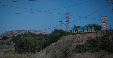 A view shows a damaged sign that reads &quot;Toretsk,&quot; panted in the colors of the Ukrainian flag, in the town of Toretsk, Ukraine, July 3, 2024. (Reuters Photo)