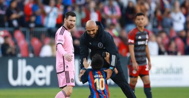 Inter Miami&#039;s Lionel Messi (L) looks on as his security guard grabs a young child who ran onto the field during a game against Toronto FC at BMO Field, Toronto, Ontario, Canada, Oct. 5, 2024. (AFP Photo)